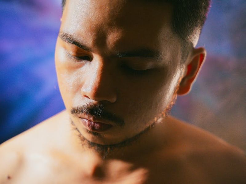 Person focused on meditation with a purple background